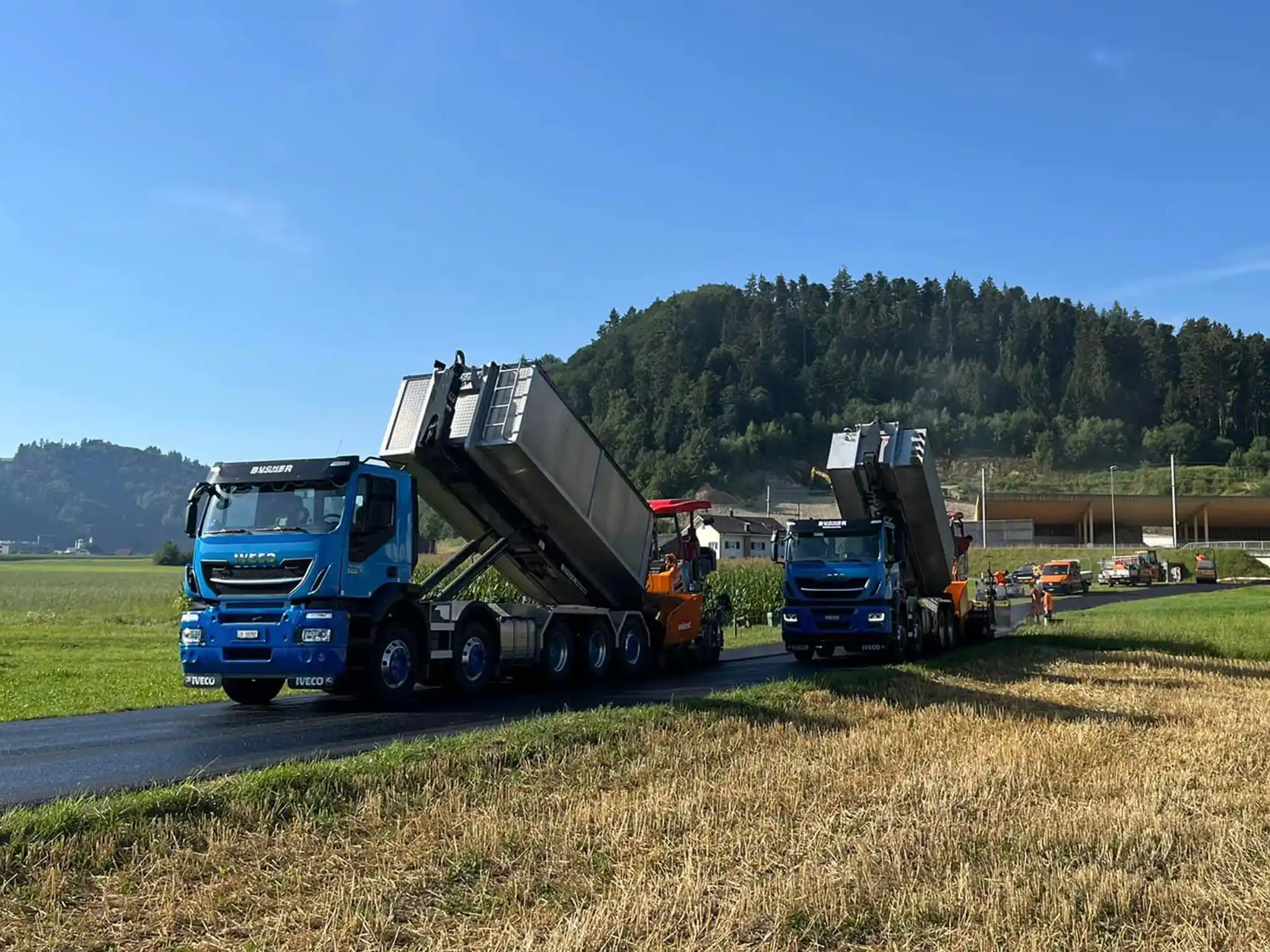 Ein Lastwagen liefert Asphalt mit dem Kipperlastwagen auf der Baustelle